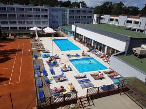 an overhead view of a pool with people sitting in chairs at Apartament Antoni Pogorzelica in Pogorzelica