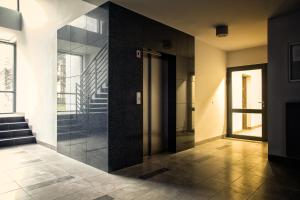 a hallway with a glass door and a staircase at Apartament Antoni Pogorzelica in Pogorzelica