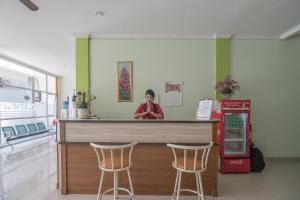 a woman standing behind a counter in a store at RedDoorz at Gatot Subroto Lampung in Bandar Lampung