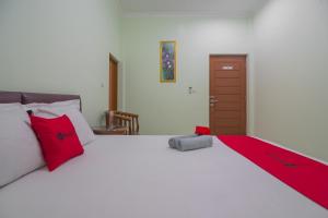 班达楠榜RedDoorz at Gatot Subroto Lampung的卧室里有一张白色的大床，上面有红色的枕头