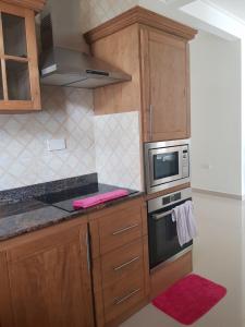 a small kitchen with a microwave and a stove at Maison Cattleya Selfcatering Apartment in Mahe