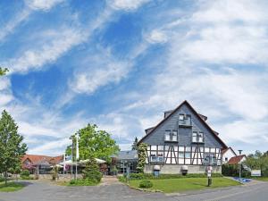 a large black and white house on the side of a street at Hotel An der Wasserburg in Wolfsburg