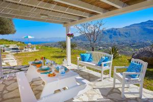 un tavolo e sedie su un patio con vista di Villa Sirena - Scopello-Villas a Scopello