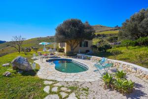 una piccola piscina in un cortile con una casa di Villa Sirena - Scopello-Villas a Scopello