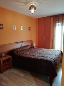 1 dormitorio con 1 cama en una habitación con paredes de color naranja en Bella Jacaranda en Marbella