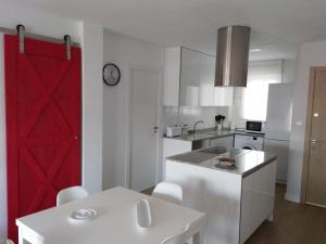 una cocina con una puerta roja de granero en Apartamento ENSUEñO en Cullera playa San Antonio en Cullera