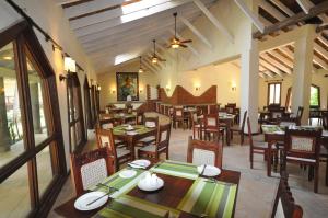 un comedor con mesas y sillas en un restaurante en Hunters Lodge, en Twaandu