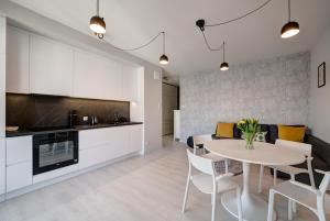 a kitchen and dining room with a table and chairs at Dom & House - Apartments Nadmorze Estate in Gdańsk