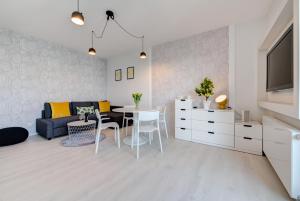 グダニスクにあるDom & House - Apartments Nadmorze Estateのリビングルーム(ソファ、テーブル、椅子付)