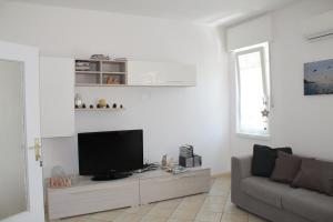 a living room with a tv and a couch at Casa Vacanze Claudette in Arco