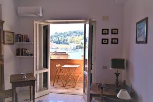 Cette chambre dispose d'une porte menant à un balcon avec vue. dans l'établissement Monolocale Porto Ercole Argentario, à Porto Ercole