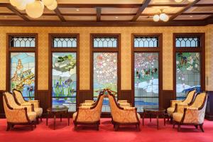 Cette chambre est dotée de chaises et de vitraux. dans l'établissement Kanazawa Hakuchoro Hotel Sanraku, à Kanazawa