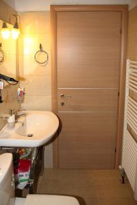 a bathroom with a wooden door next to a sink at Comfy flat with Garden near the Beach in Theologos