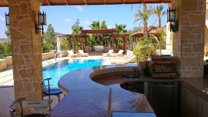 利馬索爾的住宿－Casa Carmelina，毗邻度假酒店的带桌椅的游泳池