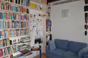 a living room with a blue couch and books at B&b Hobo in Mira