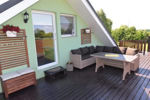 a patio with a couch and a table on a deck at Apartament u Robsona in Wilkasy