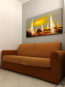 a couch in a living room with a painting of sailboats at Il Mulino in San Vito lo Capo