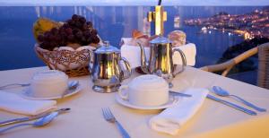 a table with plates and cups and a basket of fruit at Ocean Gardens in Funchal