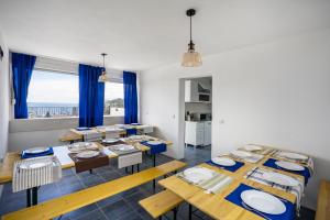 a dining room with wooden tables and blue chairs at Apartments Natali in Bar