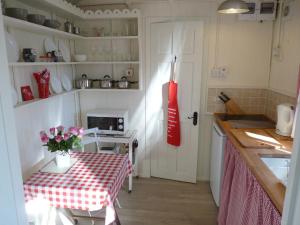 a kitchen with a table and a red and white table cloth at Romany Wagon & Cwtch in Llandysul