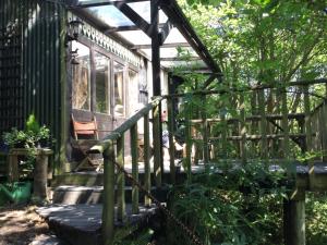 a wooden porch with a fence and a bench at Romany Wagon & Cwtch in Llandysul