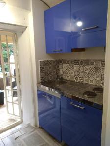 a kitchen with blue cabinets and a glass door at Villa Azur Cap d'Ail in Cap d'Ail