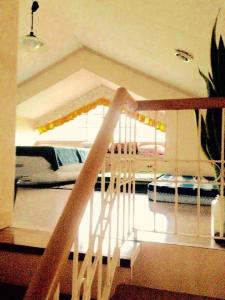 Tagaytay Budget Transient/ Staycation Home في تاجيتاي: درج يؤدي الى غرفة نوم بسرير