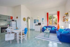 a living room with a blue couch and a table at Villa Delfino - Scopello-Villas in Scopello