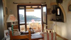 a living room with a door open to a balcony at Mare33 in Santa Teresa Gallura