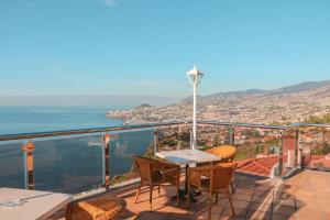 a balcony with a table and chairs and the ocean at Ocean Gardens in Funchal