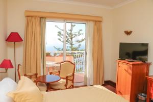 a hotel room with a bed and a balcony at Ocean Gardens in Funchal