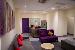 阿布賈的住宿－The Francis Hotel，一间带紫色沙发的客厅和一间厨房