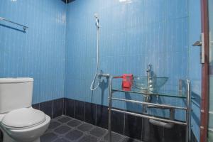 a blue tiled bathroom with a toilet and a sink at RedDoorz @ Batam Center 2 in Batam Center