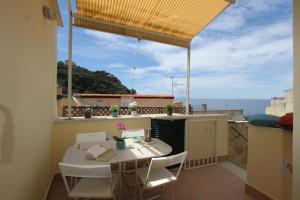 een tafel en stoelen op een balkon met uitzicht op de oceaan bij La casa sulla scogliera in Massa Lubrense
