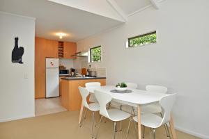 a kitchen and dining room with a white table and chairs at The Escape in Martinborough