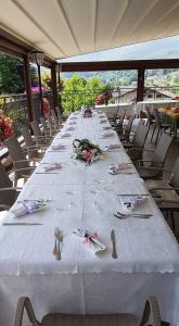a long table with forks and napkins on it at Hotel Ristorante Vittoria in San Fedele Intelvi +19 photos