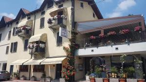 un edificio con cajas de flores y balcones en él en Hotel Ristorante Vittoria, en San Fedele Intelvi