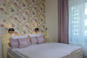 a bedroom with a bed with a floral wallpaper at Hotel Domspitzen in Cologne +63 photos