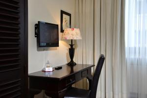 a hotel room with a desk with a lamp and a television at Hotel Domspitzen in Cologne