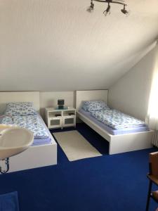 two beds in a room with a sink and a sink at Urberacher Hof in Rödermark