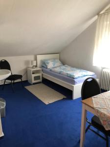 - une chambre avec un lit, une table et des chaises dans l'établissement Urberacher Hof, à Rödermark