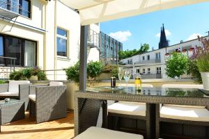 een patio met een tafel en stoelen op een balkon bij Hotel Domspitzen in Keulen