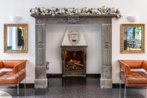 salon z kominkiem i lwią maską w obiekcie Hotel Sanpi Milano w Mediolanie +37 zdjęć