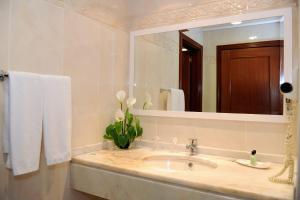 a bathroom with a sink and a large mirror at Ocean Gardens in Funchal