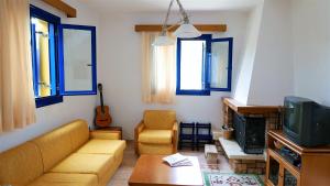 a living room with a couch and a tv at Electra Village House in Apolakkiá