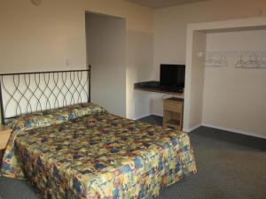 Habitación de hotel con cama y TV en Jade Mountain Motel en Chase