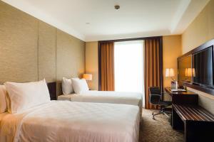 A bed or beds in a room at Swiss-Belhotel Serpong