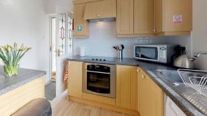 a kitchen with a sink and a microwave at Bracdy Cottage in Llandyrnog