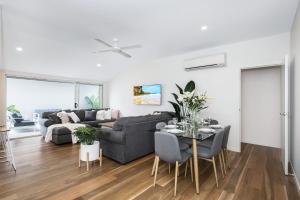 ein Wohnzimmer mit einem Sofa und einem Tisch in der Unterkunft Park Avenue Terrace House Sleeps 9 in Brisbane