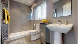 une salle de bain avec un lavabo, des toilettes et une douche dans l'établissement Bracdy Cottage, à Llandyrnog